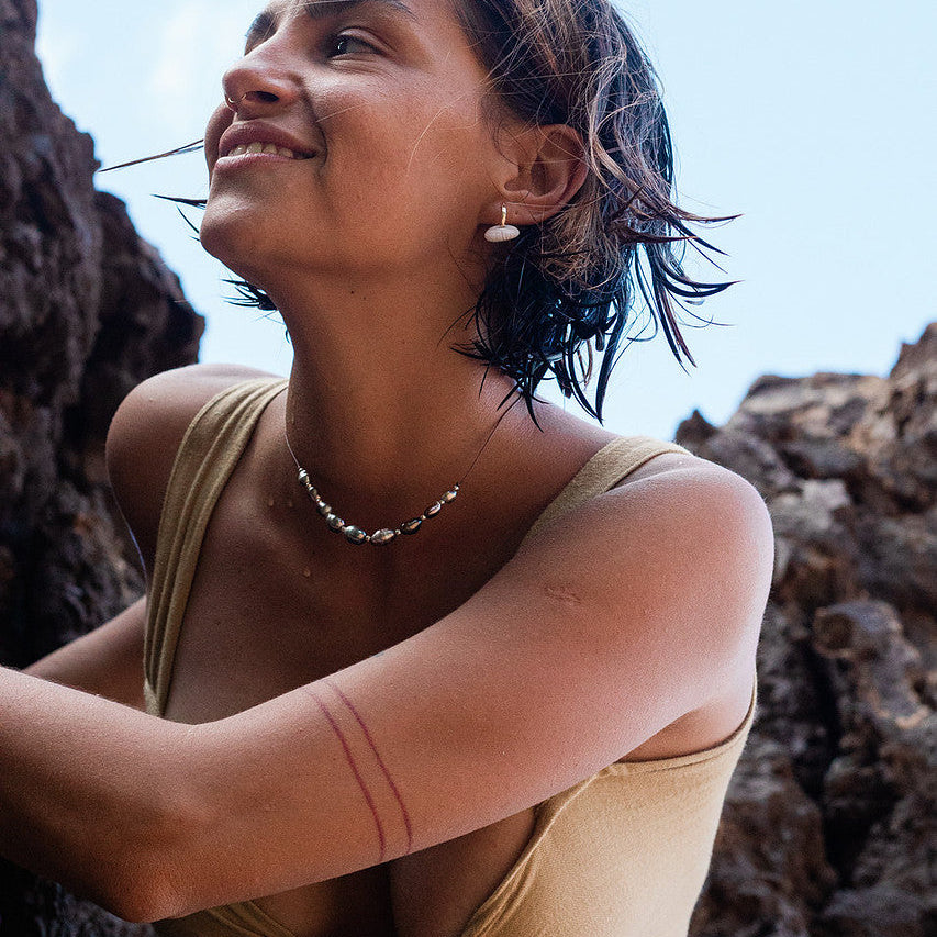 Woman sitting on rocks with a clear blue sky background