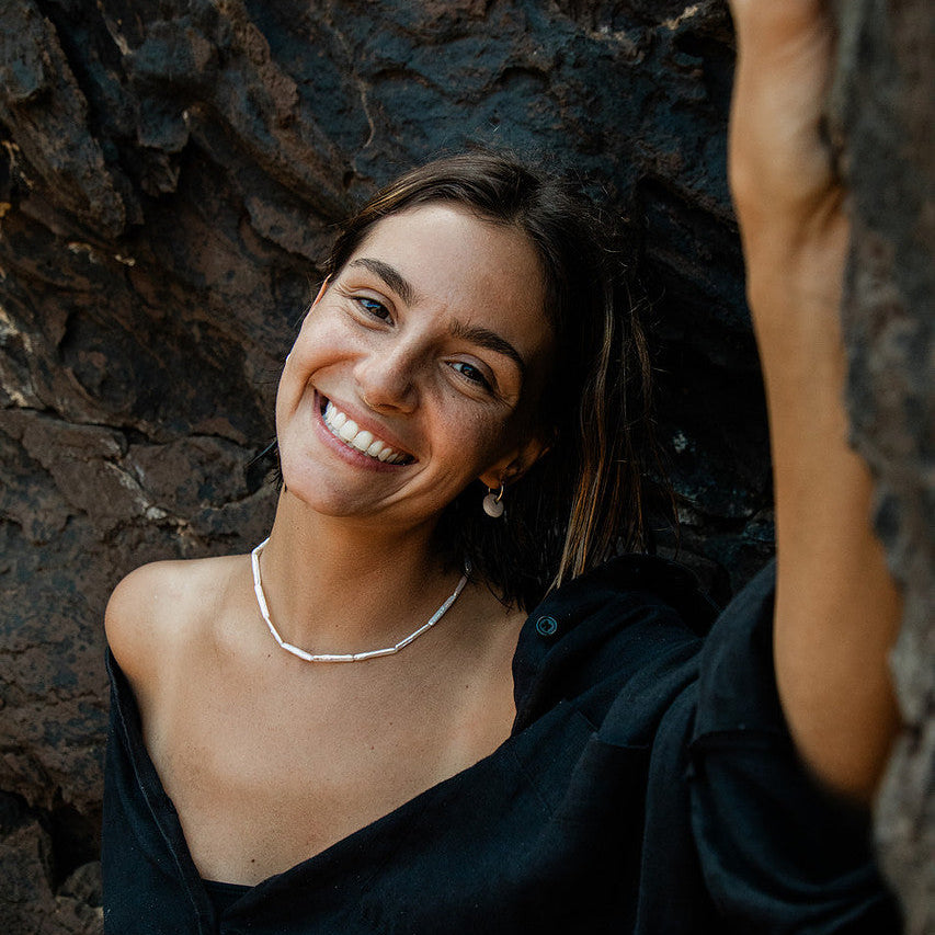 Woman smiling in a dark, textured setting
