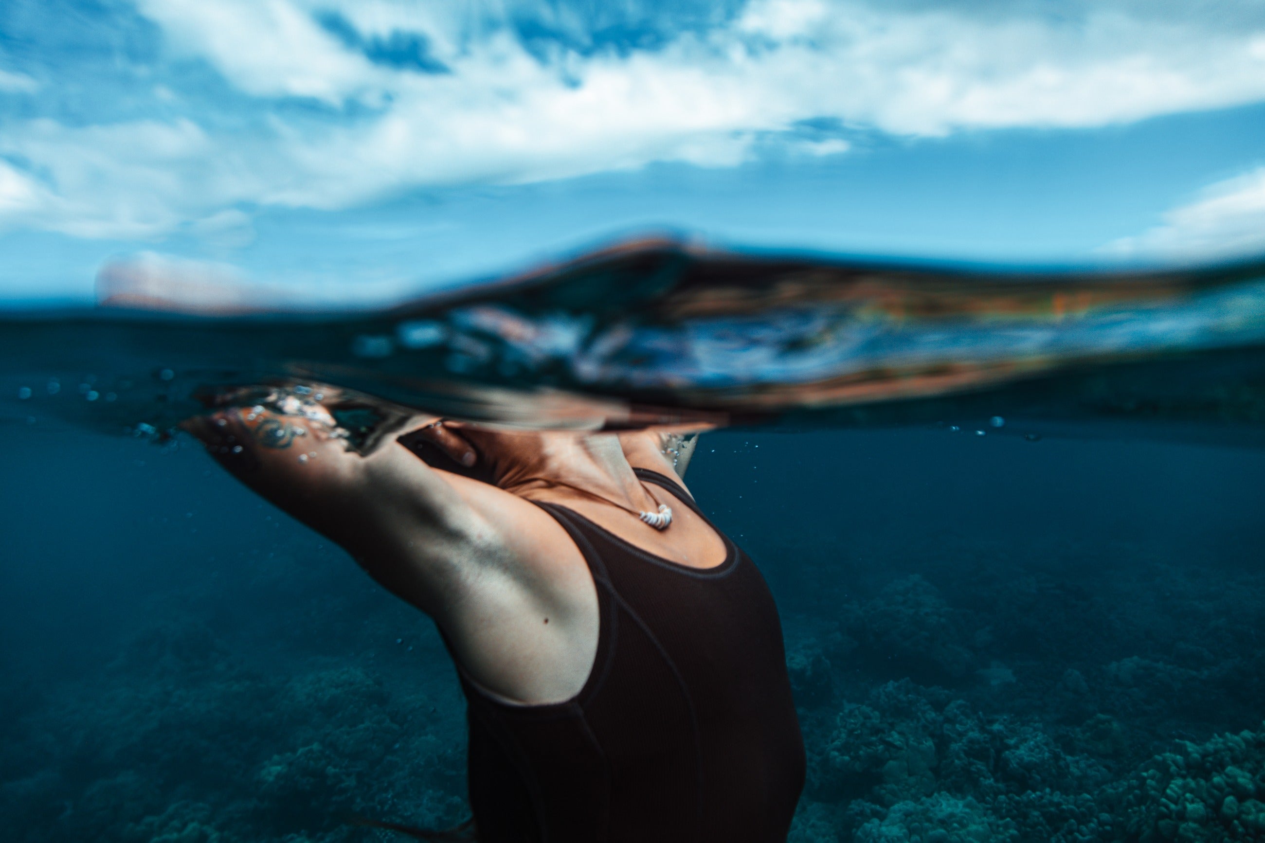 Model wearing Studio Immersed handcrafted jewelry in ocean water