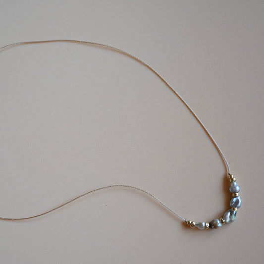 Necklace with keshi pearls on a light gray background