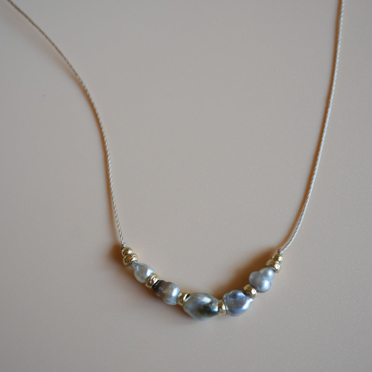 Necklace with pearls on a plain background