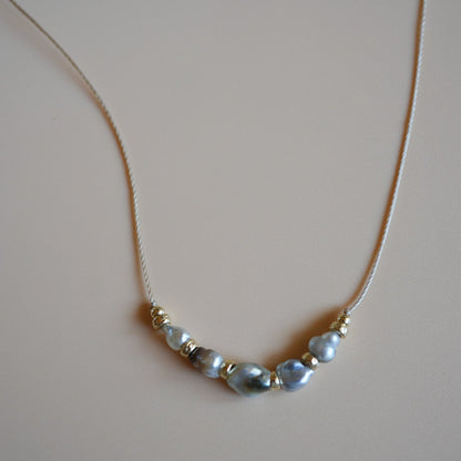 Necklace with pearls on a plain background
