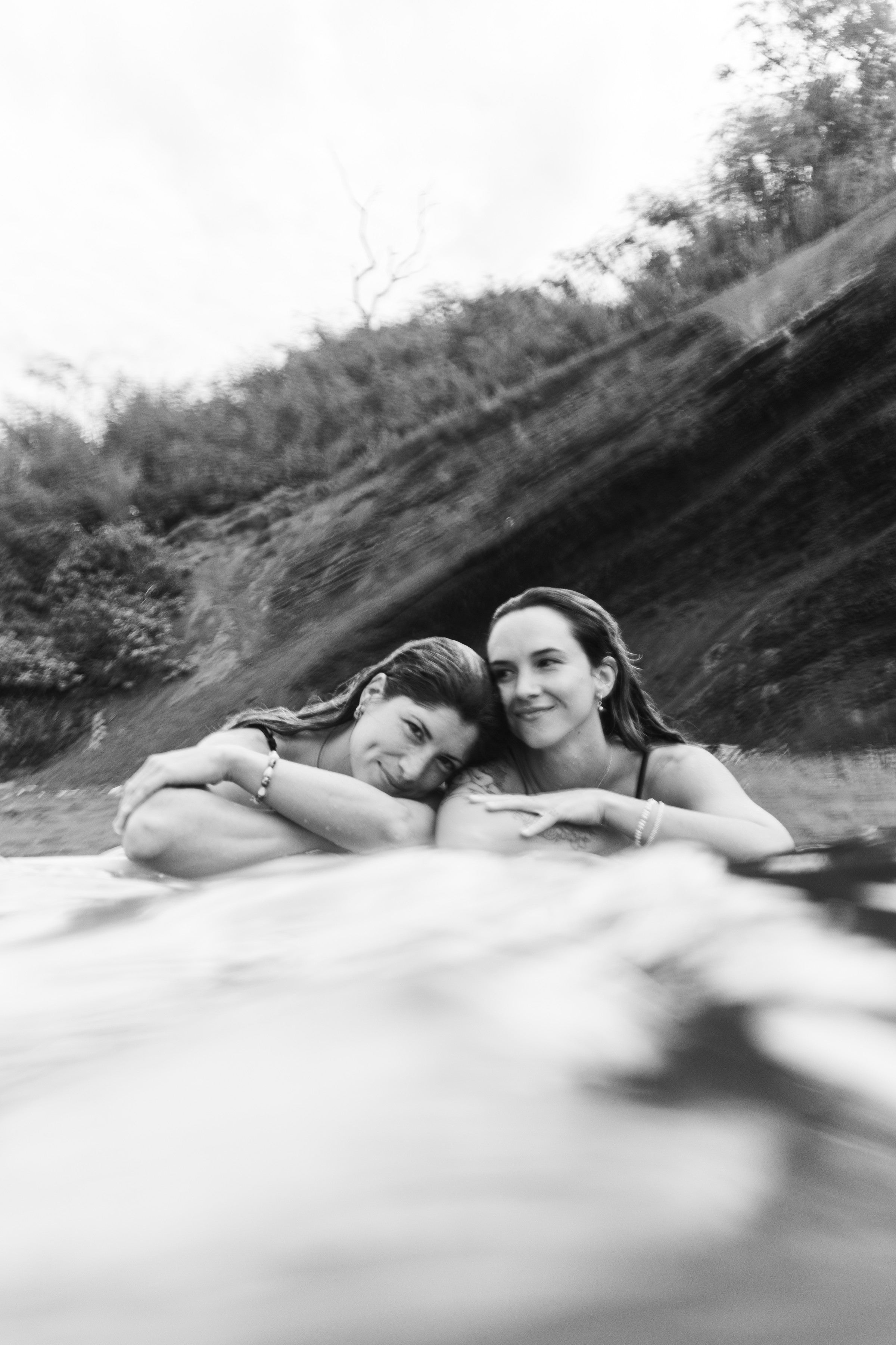 Luz Vazquez and Clara Del Castillo, founders of Studio Immersed, embracing in the ocean in Maui, Hawaii